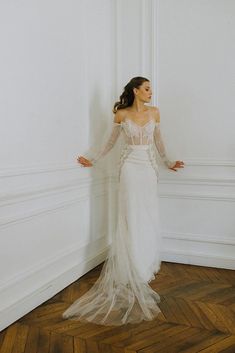 a woman in a wedding dress leaning against a wall