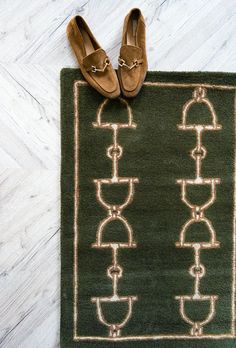 a pair of brown shoes sitting on top of a green rug