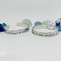 This 6” long, 3/8” wide aluminum cuff features the words “☘️ Always in our hearts ☘️“ in a beautiful “Celtic” font, centered on this bracelet cuff. On the far ends are beautiful Celtic knot hearts. Stamped inside is "Renee". I personally hand stamp all of the lettering and designs in my NJ studio. Each letter and design is hand aligned and hammered into the metal, so the placement of the wording and designs will vary slightly from piece to piece. After stamping, I darken the impressions so they Adjustable Nickel Free Cuff Bracelet For Anniversary, Adjustable Nickel-free Cuff Bracelet For Anniversary, Customizable Silver Cuff Bracelet As Friendship Gift, Meaningful Adjustable Cuff Bracelet For Anniversary, Adjustable Meaningful Cuff Bracelet For Anniversary, Celtic Fonts, Always In Our Hearts, Hand Stamped Cuff Bracelet, Celtic Heart