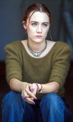 a woman sitting on the ground with her hands crossed