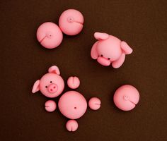 three little pink pigs sitting next to each other on top of a brown surface with one pig looking at the camera