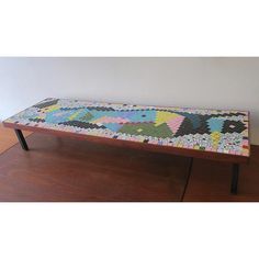 a colorful bench sitting on top of a hard wood floor