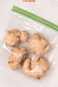 four pieces of ginger sitting on top of a plastic bag next to a green toothbrush