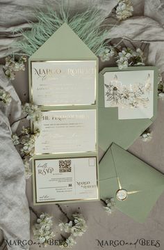 the wedding stationery is laid out on top of the bed with flowers and greenery