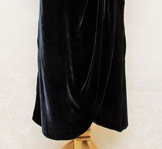 "This silk velvet dress has a dropped, asymmetrical waistline and resembles the styles of about 1930, but was made later (probably the '80's). The color is black, but with a greyish-blue cast when light plays over the surface. The skirt overlaps in front with the top portion curved and drawn up on the side and gathered, with a little pleated piece that drapes down over the skirt. There's a deep V in back and a bow with long streamers. The dress has shoulder pads, is fully lined, and has a center Vintage Velvet Dress For Evening, Vintage Velvet Dress For Night Out, Dropped Waist Dress, Dress With Low Back, Silk Velvet Dress, Bethlehem Pa, Greyish Blue, Dropwaist Dress, Bethlehem