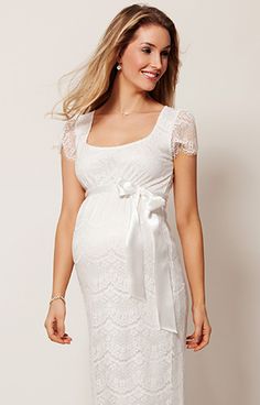 a pregnant woman wearing a white lace dress with a bow at the waist and short sleeves