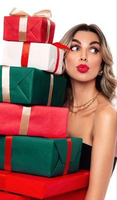 a beautiful woman holding many wrapped presents in her hands