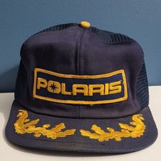 POLARIS vintage hat  Navy and gold mesh trucker cap, snapback Patch says "Polaris" with scrambled eggs on the bill Made in USA by K-Products FAIR vintage condition.  See photos for condition, and please don't hesitate to message me with any questions. Brim is broken (has folds) in several spots (see last photo), and stitching is coming out in two areas.  Patch is in excellent condition!  Some dirt spots on mesh. Vintage Yellow Snapback Trucker Hat, Vintage Navy Snapback Hat With Flat Bill, Vintage Navy Snapback Baseball Cap, Vintage Navy Snapback Hat, Gold Trucker Hat For Streetwear, Vintage Winter Trucker Snapback Hat, Vintage Winter Snapback Trucker Hat, Casual Gold Trucker Hat With Curved Brim, Vintage Trucker Hat With Embroidered Logo