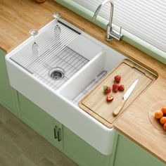 a kitchen sink with a cutting board and fruit on the counter top next to it