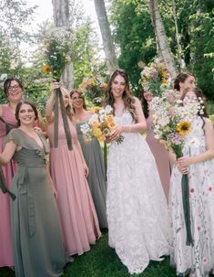 a group of women standing next to each other holding bouquets