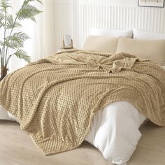 a bed covered in a blanket and pillows