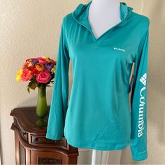 Versatile Hooded Pullover Top, Lightweight Omni Shade Fabric, V Neck Front, Teal Green Color With Contrasting White Columbia Decal Down Left Arm, Rated Upf 50 Measurements: Pit To Pit 29”, Length 24”, Sleeve Length 24” Teal Green Color, Hooded Pullover, Teal Green, Upf 50, Green Color, Columbia, Womens Tops, Shades, Sweatshirts Hoodie