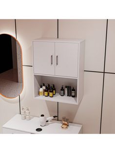 a white cabinet sitting next to a mirror on top of a counter in a bathroom