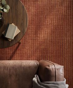 a brown couch sitting next to a wooden table