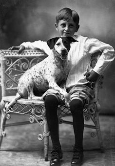 a boy sitting on a bench with his dog