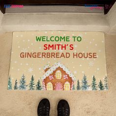 someone standing in front of a gingerbread house door mat with the words, welcome to smith's gingerbread house