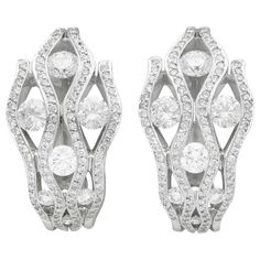 A stunning, fine and impressive pair of 2.94 carat diamond and 18 karat white gold earrings; part of our diverse vintage jewelry and estate jewelry collections. These stunning, fine and impressive vintage diamond earrings have been crafted in 18k white gold. Each earring features four vertical opposing undulating pales, ornamented with one-hundred-and-two pavé set modern brilliant round cut diamonds. Each earring is ornamented with seven modern brilliant round cut diamonds, graduating in size dependant on location. These impressive vintage earrings for pierced ears secure to the reverse with a post and hinged latch style fastening. These earrings are hallmarked to the outer surface of the hinged latch with the monogrammed maker's signature. The earrings have been independently tested using Luxury Vintage Diamond White Diamond Earrings, Vintage Diamond Earrings, Diamond Earrings For Women, Wedding Jewelry Earrings, White Gold Earrings, Vintage Diamond, Vintage Jewellery, Round Cut Diamond, Estate Jewelry