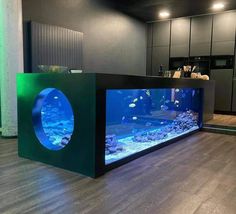 an aquarium in the middle of a room with wood flooring and lighting on it