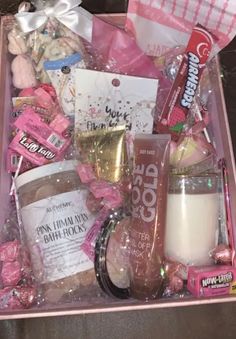 a pink box filled with lots of candy and other items on top of a table