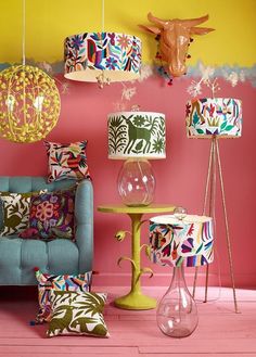 a living room filled with colorful furniture and lamps on the wall next to a blue chair