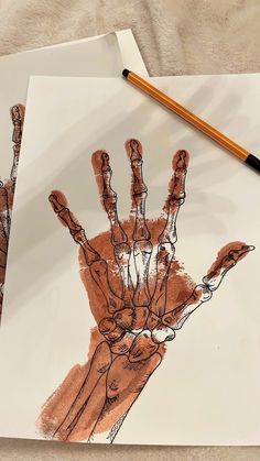 two hand prints on paper with pencils next to them