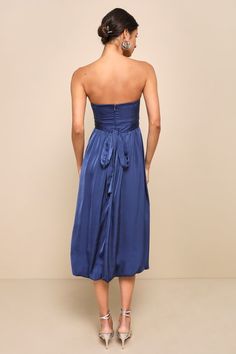 a woman in a blue dress looking back