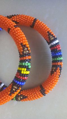 Beaded Bracelets | African Maasai Beaded Bracelets | African Jewelry | Zulu Beaded Bracelets | Ethnic Bracelets | Gift For Her | A Set Of Two These superbly crafted Zulu beaded bracelets are made of fine beads. The price is for a set of two bracelets. Main Color - Orange. Standard measurement is 7 - 8 inches. For smaller or bigger size please contact me. Available in different colors. Feel free to send me a convo or e-mail for any clarification. Thank you for visiting... Bohemian Orange Beaded Bangle Bracelets, Bohemian Orange Beaded Bangle Bracelet, Orange Bohemian Beaded Bangle Bracelet, Traditional Multicolor Beaded Bracelets With Large Beads, Bohemian Orange Beaded Bracelets With Round Beads, Bohemian Orange Beaded Bracelets, Traditional Orange Beaded Bracelets For Festivals, Traditional Beaded Bracelets With Tiny Round Beads, Traditional Orange Beaded Festival Bracelets