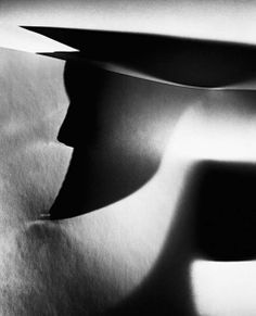 an abstract black and white photo of two paper planes flying in the air with shadows on them