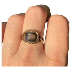 A stunning Georgian era mourning ring in a rare state of complete preservation, with all the hallmarks, original inscription, enamel and hair. All in original condition. It has a central locket compartment glazed with its original rounded, beveled glass and accessible only by a jeweler. This has a black enamel inner bezel and an engraved gold outer bezel. The beautiful hand engraved detailing continues throughout the piece. The back of the ring face is inscribed: "James Slemeck Died 16 Feb"y 1822 Aged 80.” The inside shank has four hallmarks, including the date letter "f" for 1821, 18 for the gold contest, SR for maker's mark, the London office assay marks and the British hallmarks. Measurements: Front locket part: 13 mm W x 11.5 mm H x 3 mm D Band: 4 mm W Weight: 4.2 grams Size: 7.75 (we The Ring Face, London Office, Georgian Era, Maker's Mark, Beveled Glass, Hand Engraving, Black Enamel, Beautiful Hand, Locket