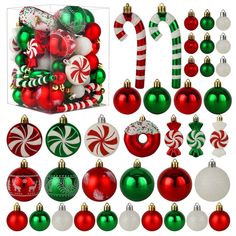 christmas ornaments and candy canes are arranged in a display box on a white background