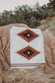 a blanket sitting on top of a large rock