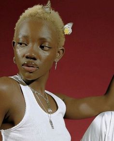 a woman in white shirt and pants with butterfly on her head