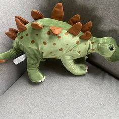 a stuffed dinosaur sitting on top of a couch