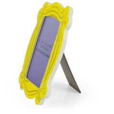 a yellow and white photo frame with a knife sticking out of the bottom one side