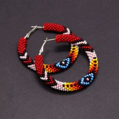 Native Americans inspired beaded hoop earrings. Absolutely eye-catching and very stylish - these earrings make a statement! Will go with any outfit, anytime, anywhere! These earrings are made of Czech seed beads and metal hoops. Hoops are approximately 2" (5cm) in diameter These earrings, whilst large, are lightweight and easy to wear. The hoops have a hinge fastening. The closure allows for peace of mind that you'll never lose an earring whilst it's being worn. A wonderful gift for her on Chris Red Bohemian Small Hoop Earrings, Bohemian Red Small Hoop Earrings, Red Festival Hoop Earrings, Red Round Hoop Earrings For Festivals, Traditional Red Hoop Earrings, Bohemian Red Hoop Earrings With Colorful Beads, Traditional Handmade Red Hoop Earrings, Handmade Red Bohemian Hoop Earrings, Red Bohemian Circular Jewelry