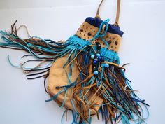 a bag with fringes and beads hanging from it's side on a white surface