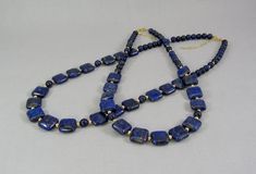 "Uniquely cut square \"pillows\" of vibrant blue lapis lazuli spaced with 14K gold filled beads create this beautiful adjustable length necklace. Two sizes are available, each with a 2 inch gold filled chain so every woman can get their best fit. The 12 mm squares are large enough to showcase the beauty of the natural stone, yet small enough for an everyday fashion accessory. Choose from 16 to 18 inch and 20 to 22 inch, that's 41-46 cm or 51-56 cm for my non-US visitors. Or send me a message to Elegant Rectangular Gemstone Beads Jewelry, Elegant Rectangular Polished Beads Jewelry, Rectangular Gemstone Beads Gold Jewelry, Gold Rectangular Gemstone Beads Jewelry, Handmade Jewelry With Blue Rectangular Stone, Gold Rectangular Jewelry With Gemstone Beads, Handmade Blue Jewelry With Rectangular Stone, Rectangular Gold Jewelry With Gemstone Beads, Blue Lapis Lazuli Rectangular Jewelry