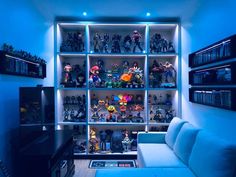 a living room filled with lots of toy figurines on shelves next to a couch