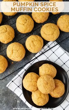 pumpkin spice muffins on a black plate next to a cooling rack with more muffins in the background