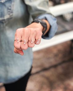 a person holding out their hand with two rings on it's fingers and the word love written in small letters