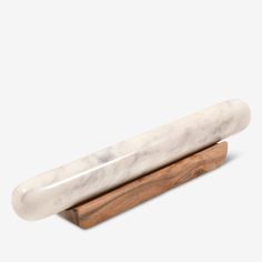 a white marble and wood object on a wooden stand