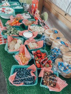 a table filled with lots of food on top of a green carpeted floor next to a window