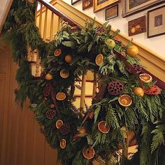 a christmas wreath is hanging on the banister in front of some pictures and paintings