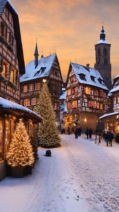 people walking down a snowy street in front of buildings with christmas decorations on the windows