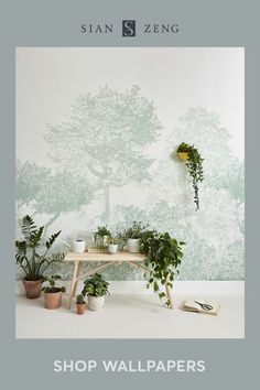 the wallpaper is green and there are plants on the table in front of it