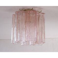 a pink glass light fixture hanging from the ceiling