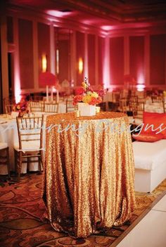 the table is set up with gold sequins and flowers for an elegant reception