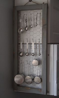 an old kitchen cabinet with pots and pans hanging from it's side wall