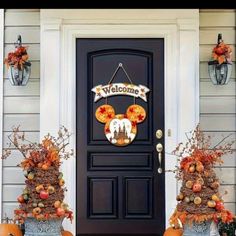 mickey mouse welcome sign with pumpkins on the front door and two large planters