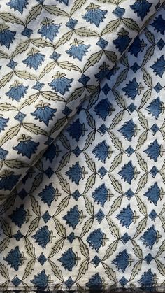 a blue and white fabric with leaves pattern on it's back ground, close up